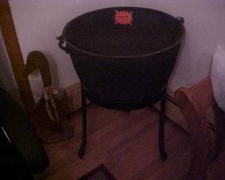 A gigantic cast Iron cauldron and stand.