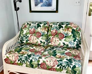 Ratttan loveseat with floral cushions