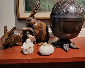 Pair of antique cast Japonese bronze rabbits, a cast bronze twine bank, and two Netsukes.