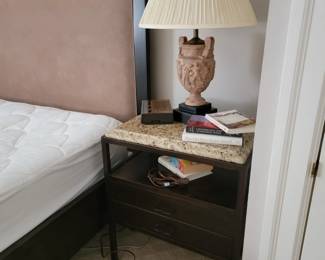 Headboard and frame the mattress is a Sleep Number Bed.  There are a pair of classical form lamps and two stone topped nightstands.