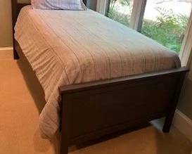 Twin bed with new mattress and box spring, linens included. Mattress has special flocked and waterproof cover. 