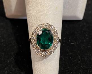14 kt gold oval lab created emerald with diamond halo ring.