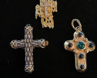 Left to right-- sterling and 18 kt gold cross $450. Gold and diamond cross $1200. Gold and sapphire cabochon with beryl cabochon center 14kt. $1200.