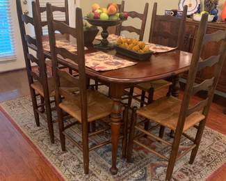 Wooden dining table with 6 woven cane bottom ladder back chairs