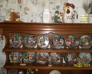 A dozen collector Hummel plates that all include the certificate of authenticity with them.