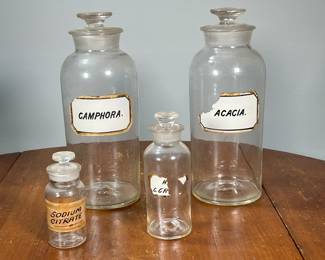 (4PC) BLOWN GLASS APOTHECARY JARS | Including two large jars, one Camphora another Acacia, plus two smaller jars. - h. 11.5 in (tallest)

