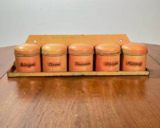 (5PC) TIN SPICE JARS WITH WALL RACK | A set of five tin spice canisters, each labeled: Ginger, Cloves, Cinnamon, Allspice, Nutmeg; with a conforming wall shelf. -  l. 15 x w. 4 x h. 4-1/2 in
