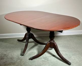 MAHOGANY DINING TABLE | Mahogany wood dining table with two extension leaves, of nicely figured wood, with carved double pedestal legs. - l. 63-1/2 x w. 38-1/2 x h. 29 in
