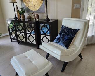 Three piece console with mirrored doors and white lounge chair with ottoman