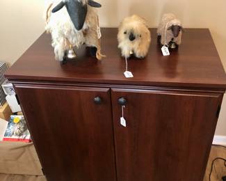 Small cabinet and 3 woolly sheep, 1 big, 2 small.