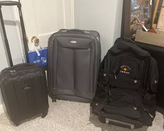 Lower Level:  Two pieces of clean/quality SAMSONITE luggage on wheels are to the left of a World Tour LUCAS bag which is also on wheels.