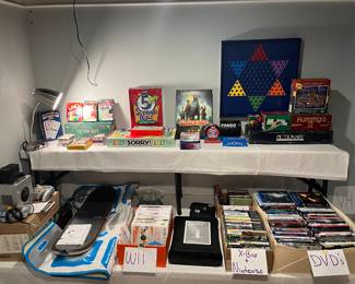 Lower Level:  This is the gaming department:  playing cards; board games; Wii; Nintendo; X-Box games are near a Wii system; NINTENDO cube; Tony Hawk board; and X-Box 360.  Also shown are DVDs and CDs.  