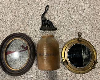 Lower Level:  An antique oval frame with glass is to the left of a vintage cast iron embosser (Gunkel  Barber Supply Co.); a "W. & S. Co." stoneware jar; and a 11-1/2" brass/glass porthole nautical maritime wall mirror.
