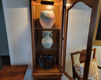 Lighted curio with pottery
