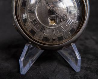 A silver pocket watch held in a silver case, made by Will Kipling of London. Circa 1720's. A silver face with Roman and Arabic numerals and a date counter. Engraving "K0266". Inside is marked "TN" and "1065". 1065 is also marked on the watch mechanism and is believed to be the pieces serial number. No key.
