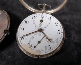 A silver pocket watch in a silver case, with an enamel face and Arabic numerals. Made by Thomas De Lasalle circa late 1700's. The back of the watch movement is engraved "J. De Lasalle London" and "1329".