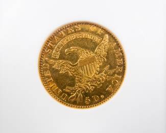 An 1823 $5 Capped Bust Half-Eagle Gold Coin. Graded an AU-50 by NGC. This coin also has a CAC Gold Sticker, meaning CAC believes the quality of the coin may warrant a higher grade. It is estimated there are 80 to 100 surviving examples of this coin. The design features are well brought up in most areas. The semi-reflective green-gold surfaces display pleasing coral color near the peripheries.