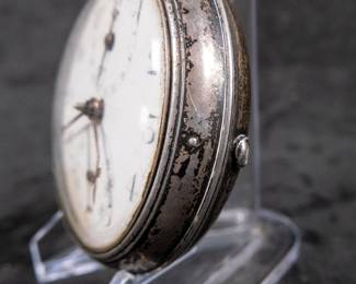 A silver pocket watch in a silver case, with an enamel face and Arabic numerals. Made by Thomas De Lasalle circa late 1700's. The back of the watch movement is engraved "J. De Lasalle London" and "1329".