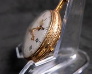 An 18K gold pocket watch with an enamel face and both Roman and Arabic numerals, and an artistic enamel back. Made by watchmaker Jean Romilly circa 1780-1790. The face and back of the movement are both inscribed "Romilly A PARIS"