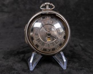 A silver pocket watch held in a silver case, made by Will Kipling of London. Circa 1720's. A silver face with Roman and Arabic numerals and a date counter. Engraving "K0266". Inside is marked "TN" and "1065". 1065 is also marked on the watch mechanism and is believed to be the pieces serial number. No key.