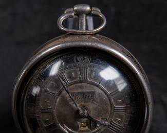 A silver pocket watch held in a silver case, made by Will Kipling of London. Circa 1720's. A silver face with Roman and Arabic numerals and a date counter. Engraving "K0266". Inside is marked "TN" and "1065". 1065 is also marked on the watch mechanism and is believed to be the pieces serial number. No key.