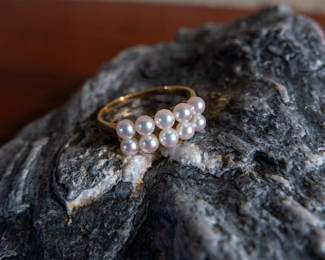An 18kt Gold ring adorned with ten pearls. Size 7. Total weight 2.5 grams.