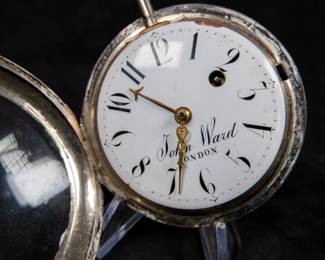 A silver pocket watch with an enamel face and Arabic numerals signed on the face "John Ward LONDON", made by watchmaker John Ward of London, late 18th Century. The movement on the back is signed "John Ward Fore Street London" Number 2640. The back movements shows a monogram of King George III, with two "G"s one reversed, and the Roman numerals III with a crown affixed on top.