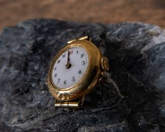 An 18k gold lady's wrist watch. The watch is missing it's glass cover but is still ticking and working. Serial #636653. Total weight 13.84 grams.