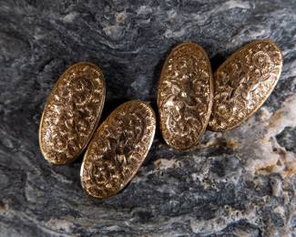 A pair of 10K gold Edwardian cuff links. A beautiful pair of gold cuff links with an ornate carved design and a small floral centerpiece. Total weight 4.41 grams.