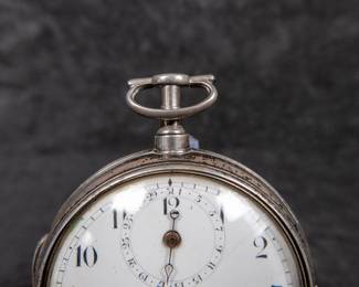 A silver pocket watch in a silver case, with an enamel face and Arabic numerals. Made by Thomas De Lasalle circa late 1700's. The back of the watch movement is engraved "J. De Lasalle London" and "1329".