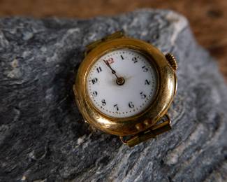 An 18k gold lady's wrist watch. The watch is missing it's glass cover but is still ticking and working. Serial #636653. Total weight 13.84 grams.