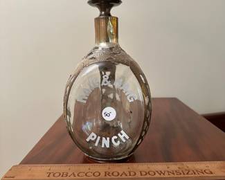 T85 - $50. Sterling wrapped Haig & Haig Pinch Bottle. Has decanter lid but the cork has fallen off)