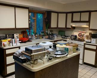 Lots of kitchen appliances such as vintage rival crock pots, electric griddle, George Forman indoor grill, large microwave, cuisinart food processor, and much moore