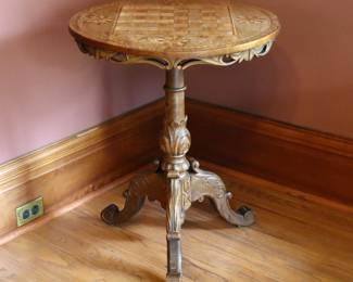 A 19th century Victorian Period tilt-top game table. Walnut construction with spinning circular top and inlaid checkerboard, on a carved pedestal base with cabriole legs. Original finish with wear particularly to game top, some shrinkage and very minor damage. 23 1/5 x 23 1/2 x 29 1/2" high overall. NOTE: This lot picks up from the home in Coldwater, Michigan.