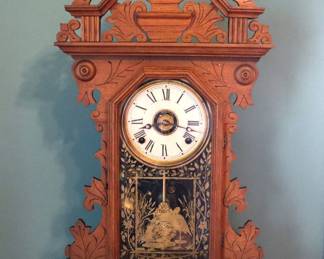 A 19th century Victorian Period Welch & Co. kitchen clock. 8-day time and strike with painted metal dial and Roman numerals. Walnut case with shaped crest over a single door with stenciled glass and molded base. Paper labels 10%. Older refinishing with minor wear, dial crazing, small nail in front, includes key, running when cataloged. 16 1/4 x 5 1/4 x 24" high overall. NOTE: This lot picks up from the home in Coldwater, Michigan.