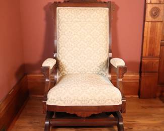 A 19th century Victorian Period rocker. Mahogany construction with carved crest over an upholstered back, arms and seat on a platform rocking base. Older refinishing with minor wear and scuffs, some shrinkage and minor insect damage. 24 x 28 x 42" high overall. NOTE: This lot picks up from the home in Coldwater, Michigan.