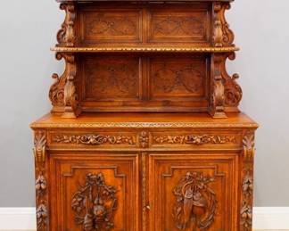 A late 19th century Victorian Period dining room buffet. Oak construction with extensive hand carved decoration features an upper section with open shelves supported by foliate brackets, shaped back with foliate scrolls and carved Stag head, o a base with tow Silver drawers over two doors with carved game panels. Old finish with some wear, joint shrinkage in top. 55 x 22 x 83 1/2" high overall. NOTE: This lot picks up from our Ypsilanti, Michigan facility.