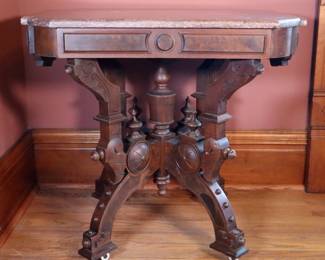 A 19th century Victorian Period parlor table. Walnut construction with Burl detail, shaped Marble top and conforming apron over a carved stretcher base with turned stem and curved legs. Older finish with some wear and scuffs, crescent shaped repair to Burl inlay on one leg, minor shrinkage and damage. 32 x 23 x 30" high overall. NOTE: This lot picks up from the home in Coldwater, Michigan.