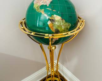 A rotating gemstone globe on floor stand