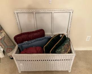 White wicker chest; decorative pillows