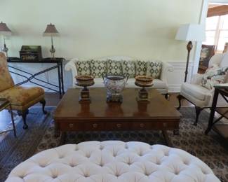 Neutral traditional sofa, decorative pillows, pair of neutral wing chairs, pair of armless accent chairs, coffee table, mahogany 3 tier side table, console table, neutral ottoman, area rug, bric-a-brac