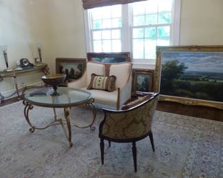 Ornately framed decorative art, settee, brass coffee table, demilune brass console table, accent chair, area rug