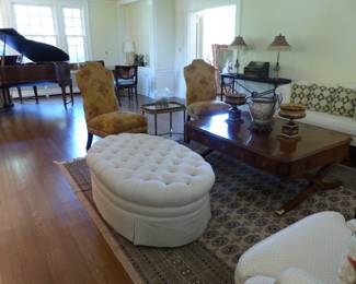 Neutral ottoman, pair of armless accent chairs, small brass tray side table