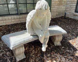 A lonely little angel sitting on a bench!