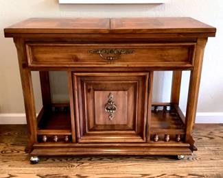 GRLI201 Thomasville Fliptop Buffet Table Made by Thomasville is this flip-top buffet with a single drawer and a cabinet below. Does have brass wheels with rubber rollers.
