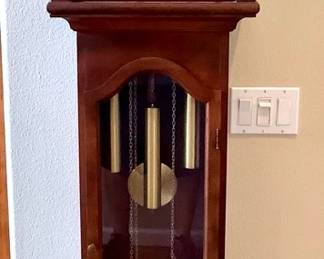 GRLI200 Colonial Chippendale Style Grandfather Clock Buy Colonial Mtg Company with 3 weights and a pull chain. Has the open pediment top with flanking scrolls center. Looks to be in working condition.
