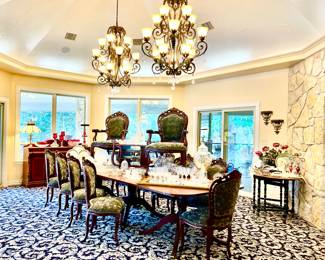 SPACIOUS DINING ROOM WITH A VERY LONG TABLE AND 12 CHAIRS.