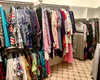 TWO LARGE CLOSETS STUFFED FULL OF WOMEN'S CLOTHING.