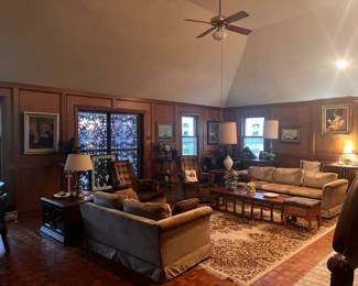 Gold velvet entertaining/conversation couches, matching gold swivel chairs, large vintage area rug, brass lamps, collectible lamps, large framed artwork, wooden sculptures.