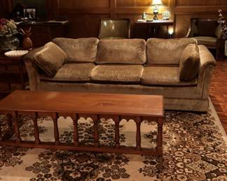 Wooden coffee table, gold velvet entertaining/conversational couch, large vintage area rug, framed art work, vintage lamps